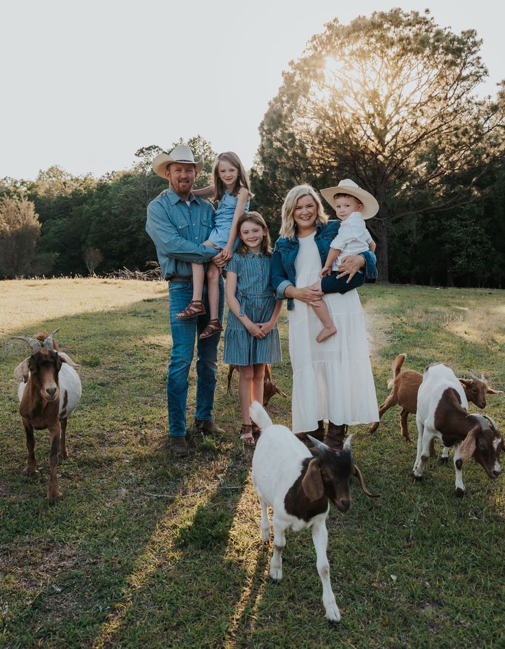 a family poses for a photo with their goats