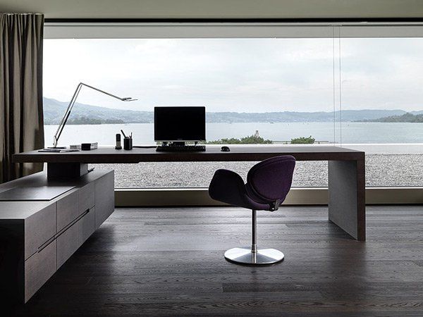 a desk with a computer on it in front of a large window overlooking the water