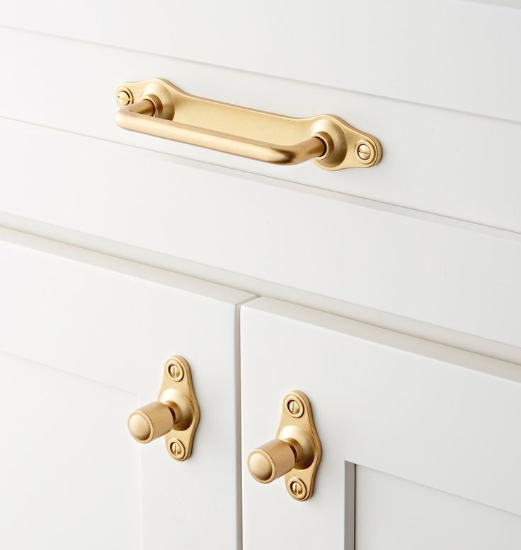 an image of white drawers with gold handles and knobs on the front door handle