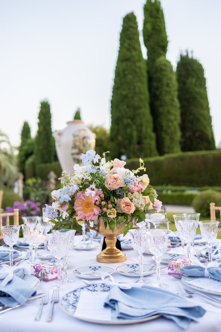 the table is set with blue and pink flowers