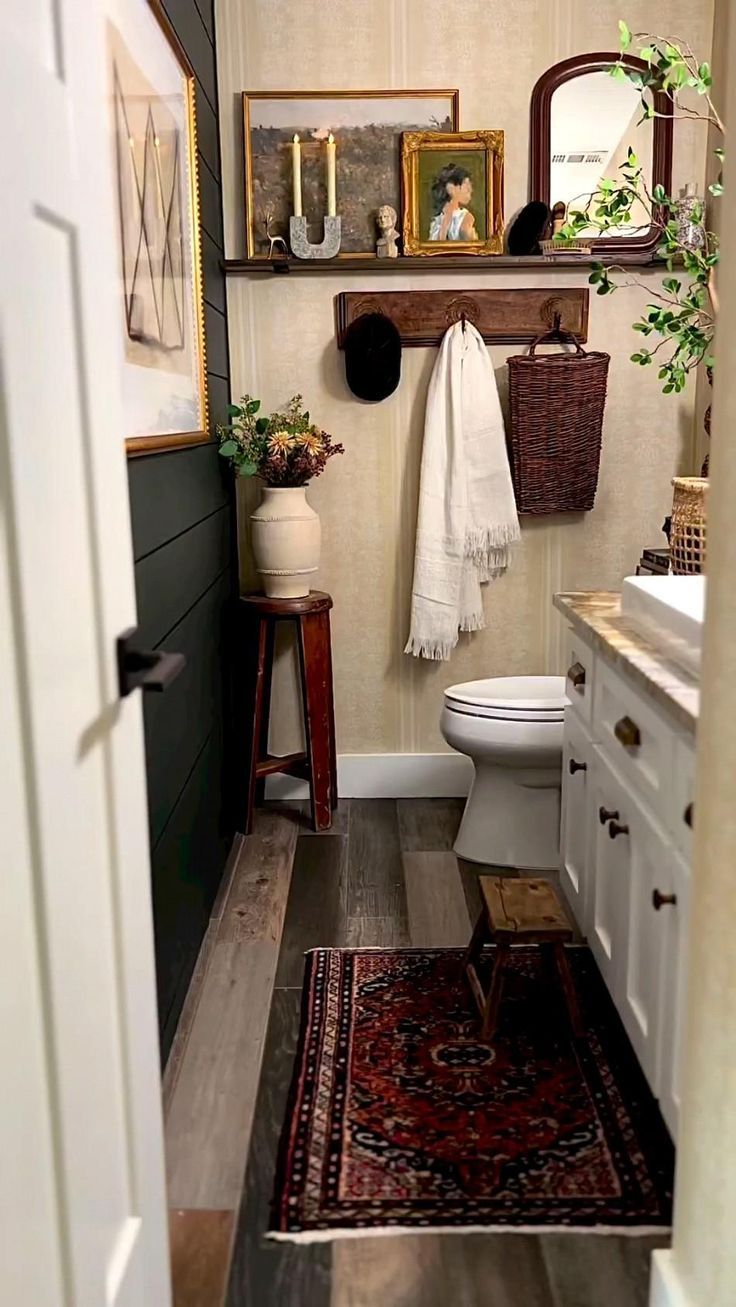 a white toilet sitting in a bathroom next to a wooden cabinet and rug on top of a hard wood floor