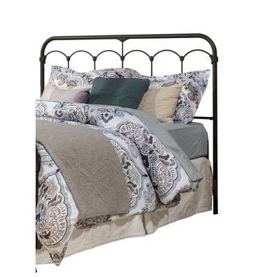 an iron bed frame with pillows and blankets on it's headboard, against a white background