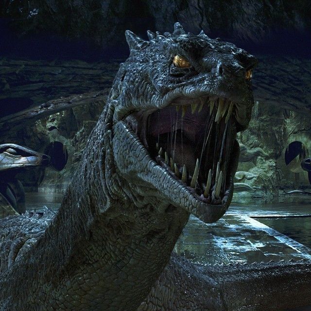 a large dinosaur with its mouth open and teeth wide open in front of other dinosaurs