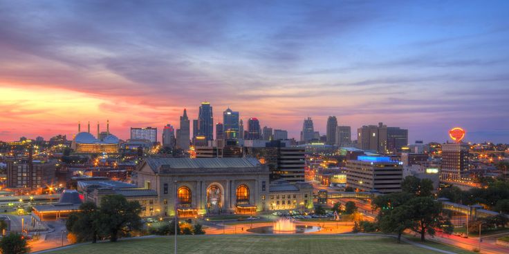 the city skyline is lit up at night, with lights on and buildings in the background