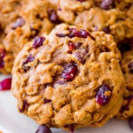 three cookies with cranberries on a white plate