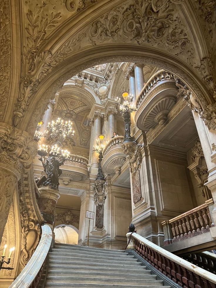 an ornate staircase with chandeliers in a building