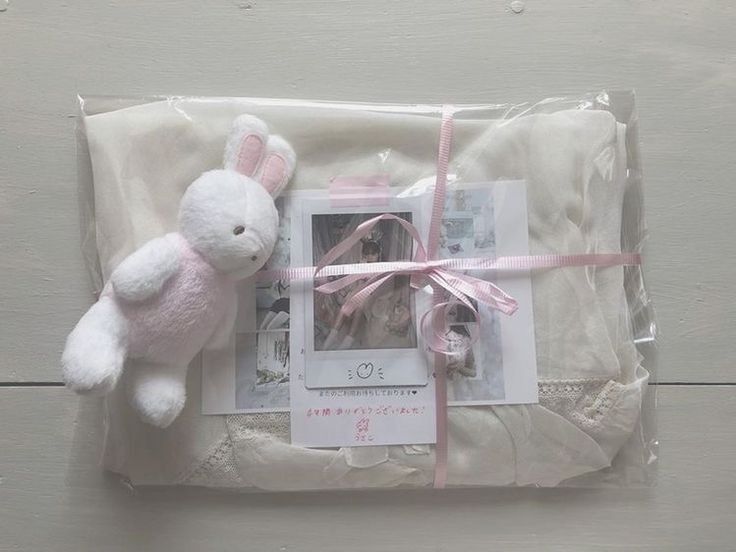 a white stuffed animal laying on top of a package