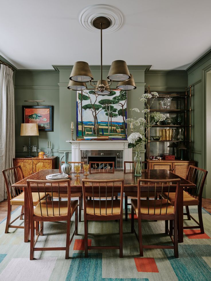 a dining room with green walls and wooden chairs