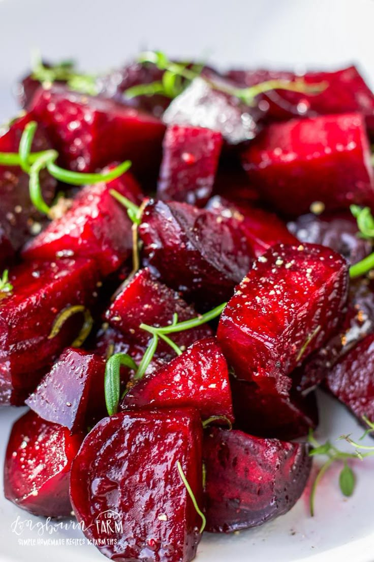 a white plate topped with sliced beets covered in ketchup and garnish