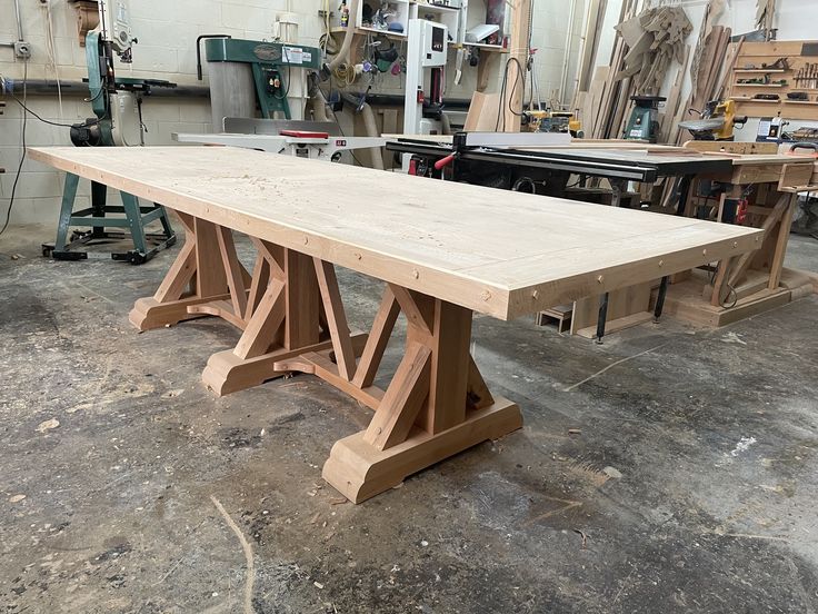 a long wooden table in a workshop with tools