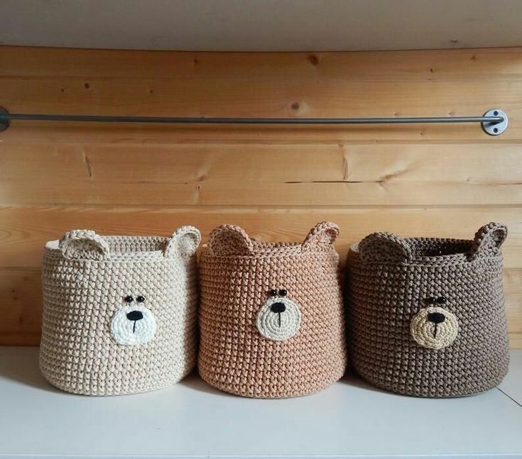 three crocheted baskets with teddy bears on the front, one brown and one white