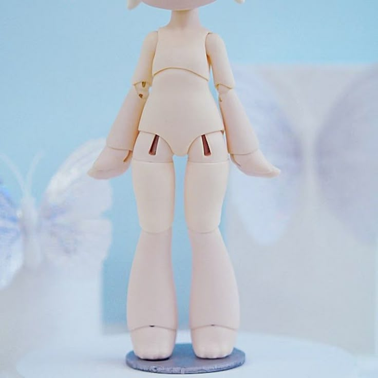 a white doll is standing on a blue base