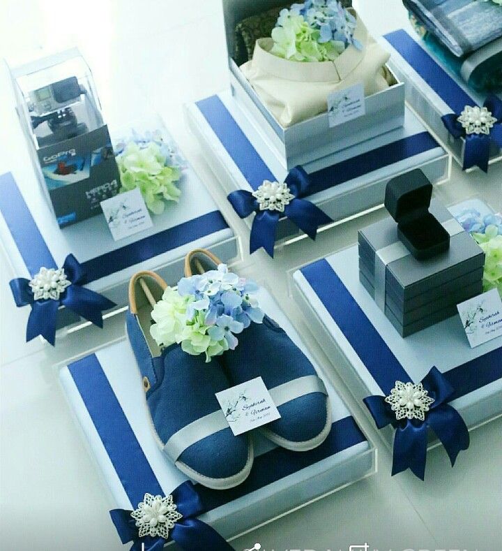 blue and white shoes are on display with flowers in the middle, along with other items