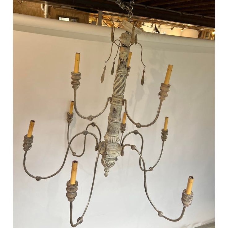 a chandelier hanging from the ceiling with five candles attached to each light fixture