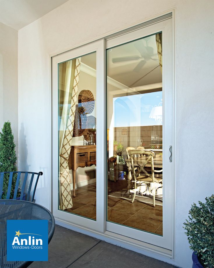 an outdoor patio area with table and chairs next to sliding glass doors that look out onto the deck