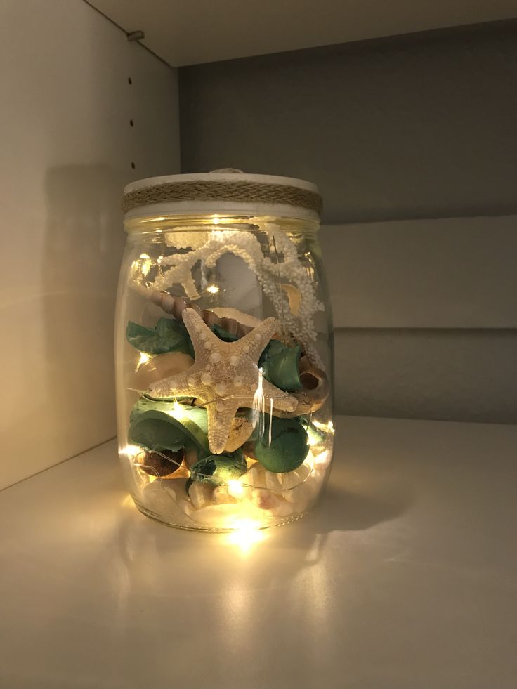 a jar filled with sea shells and lights