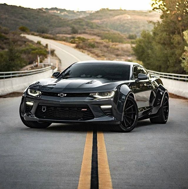 a black sports car driving down the road