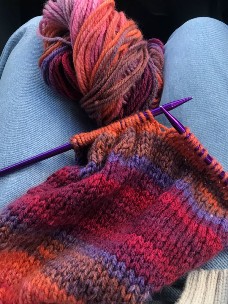 yarn and knitting needles on the lap of someone's lap