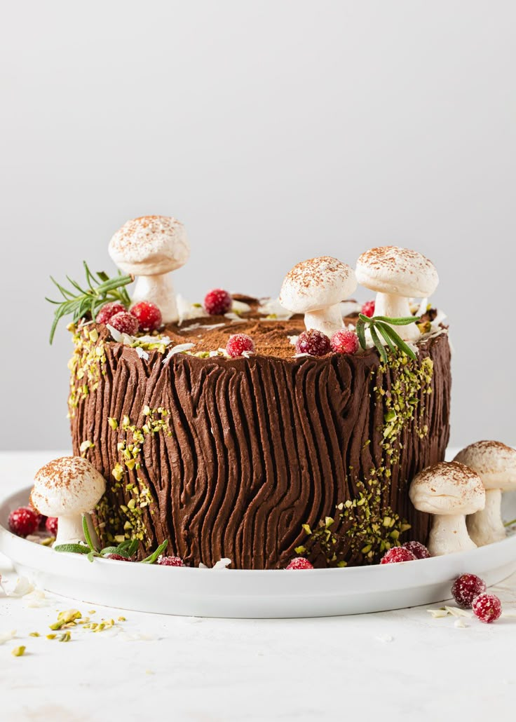 a chocolate cake with mushrooms and berries on top