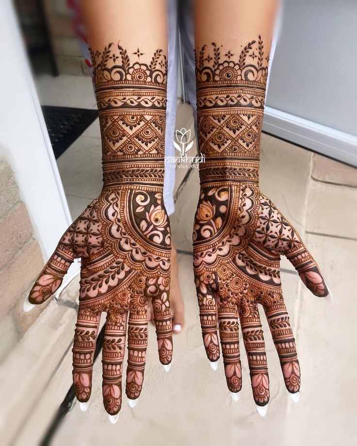 two hands with henna designs on them