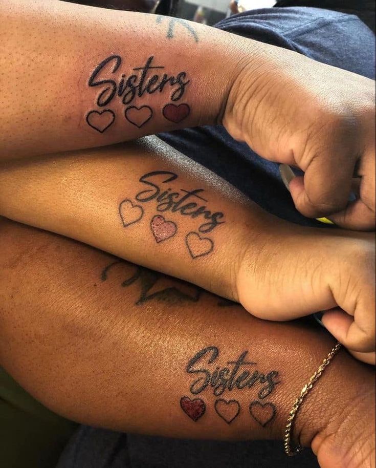 two people with tattoos that say sisters and sons on their arms, one is holding the other