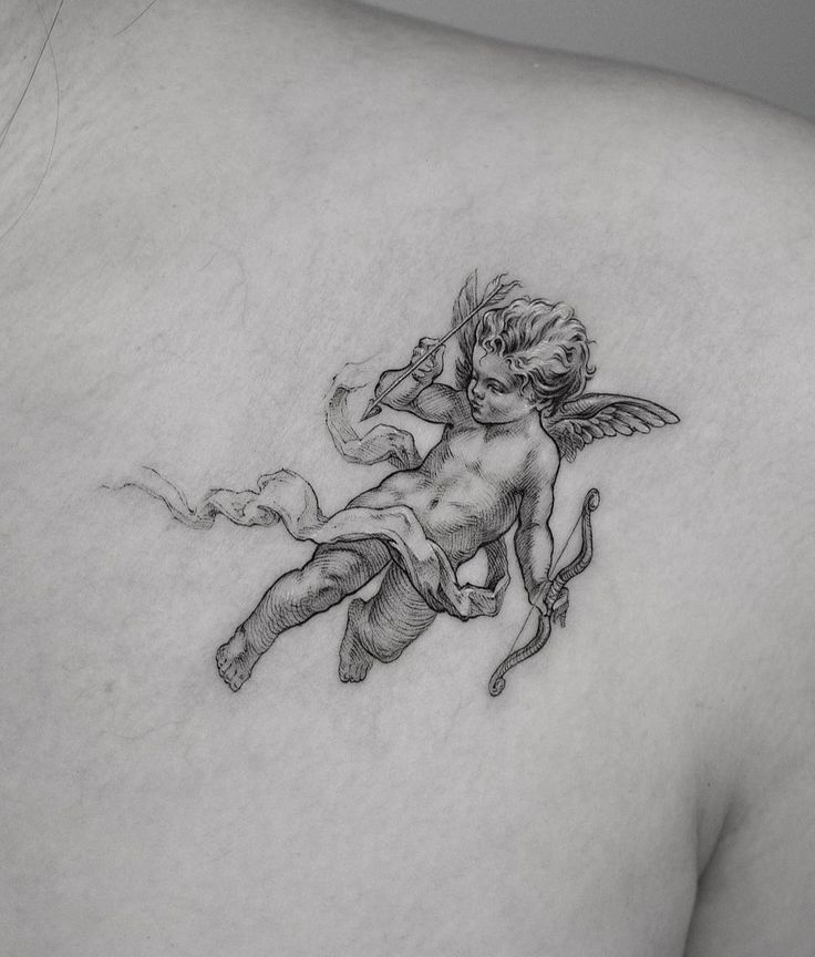 the back of a woman's shoulder with an angel tattoo on it