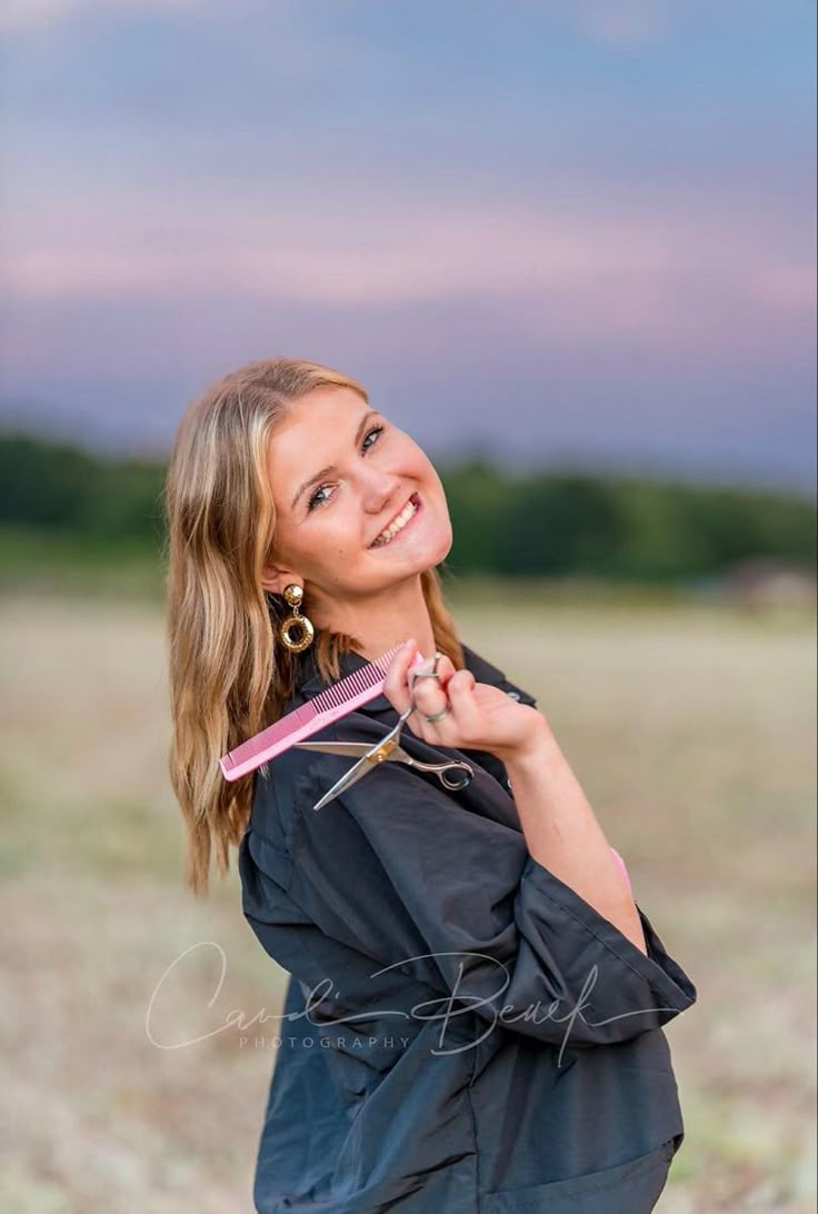 a woman holding a pink toothbrush in her right hand and smiling at the camera