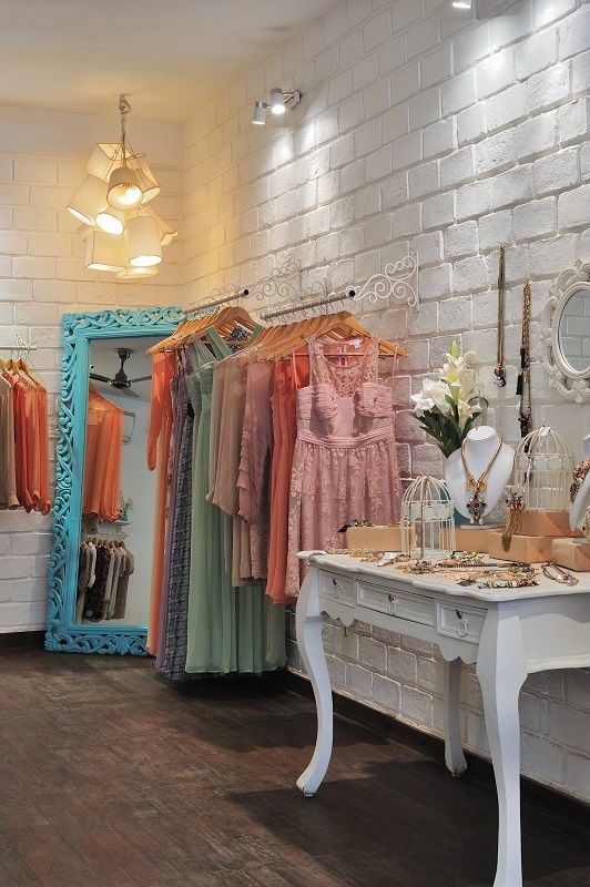 a clothing store with white brick walls and wooden floors