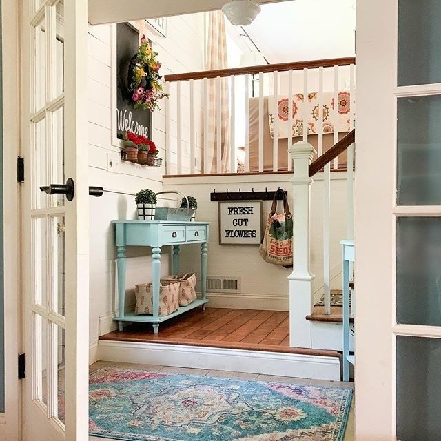 an open door leading to a room with a rug on the floor and stairs in it