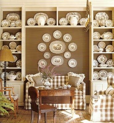 a living room filled with furniture and plates on the wall