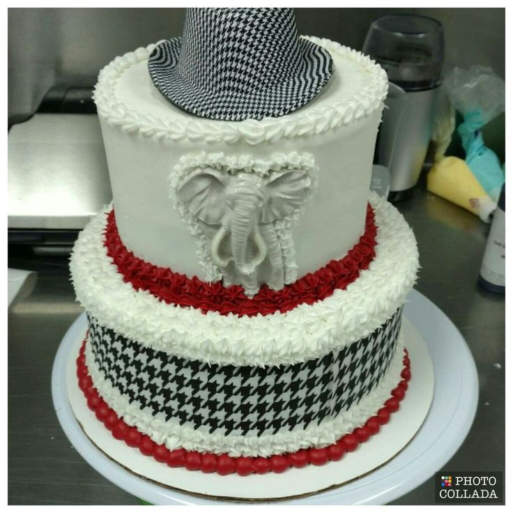 a three tiered cake with an elephant on top and red, white, and black stripes