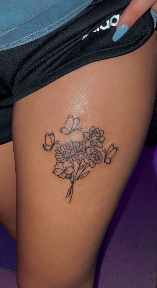 a close up of a person's thigh with flowers and butterflies on the side