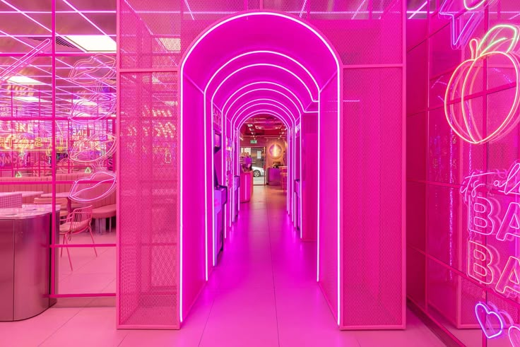 the interior of an apple store with pink neon lights and arches leading into the room