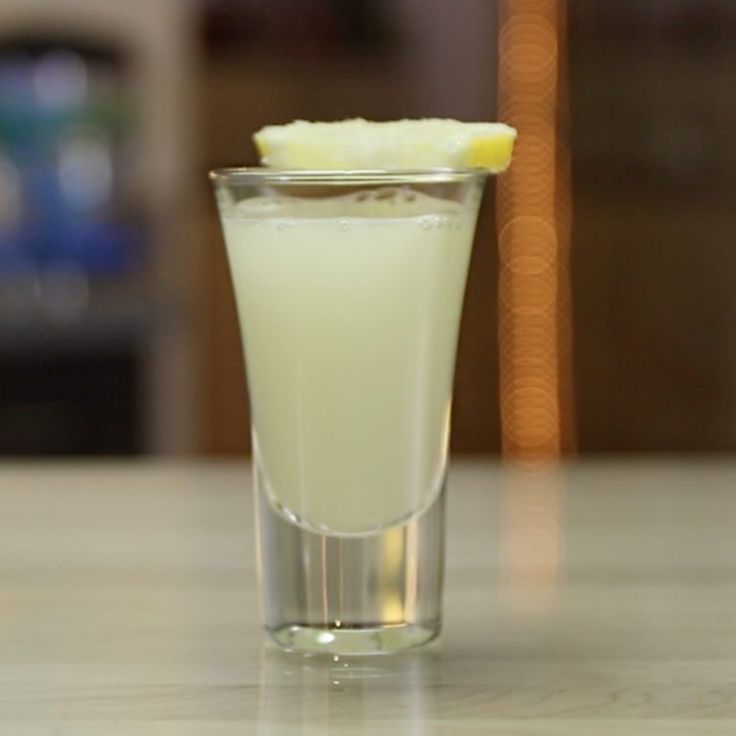 a glass filled with liquid sitting on top of a table