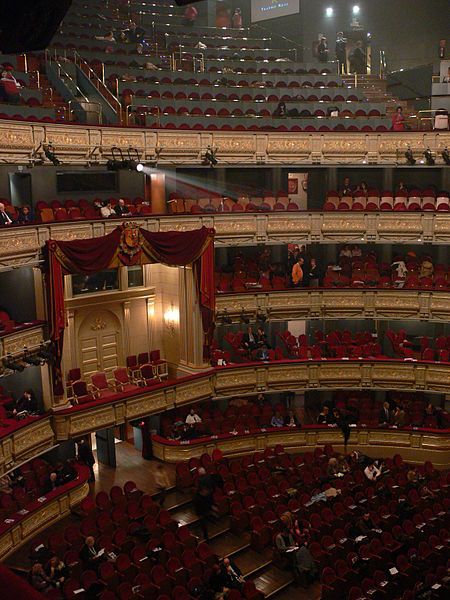 an auditorium filled with lots of red seats