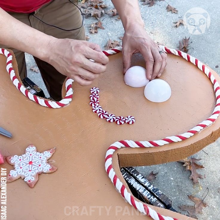 a person is decorating a wooden table with candy canes and an egg on it