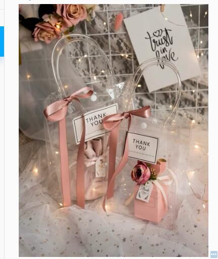 two small bags with pink bows and tags in front of a sign that says thank you