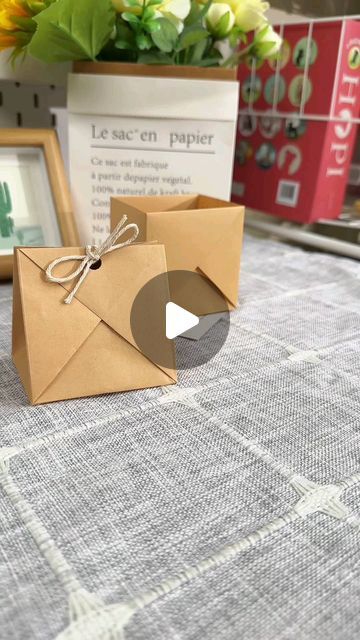 an open envelope sitting on top of a table next to a vase with flowers in it