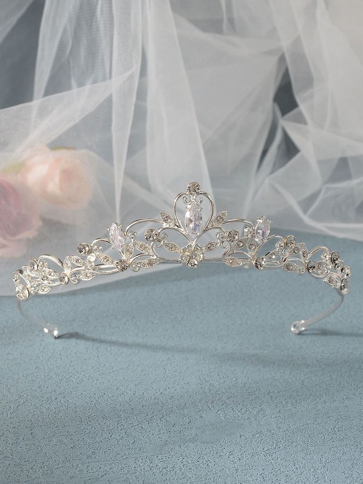 a bridal tiara with crystal stones and pearls on the headband is laying on a blue surface