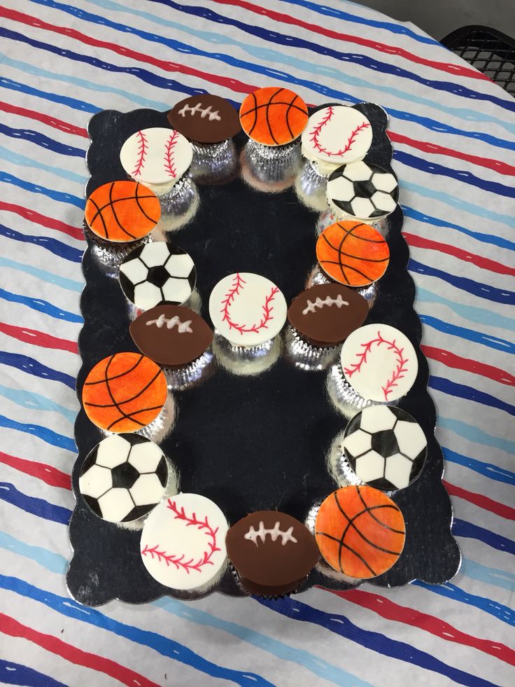 cupcakes are arranged in the shape of a wreath with sports balls on them