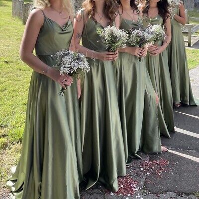 a group of women standing next to each other wearing green dresses and holding bouquets