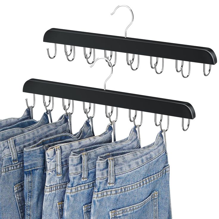 four pairs of jeans hanging on hooks in front of white background with clippings