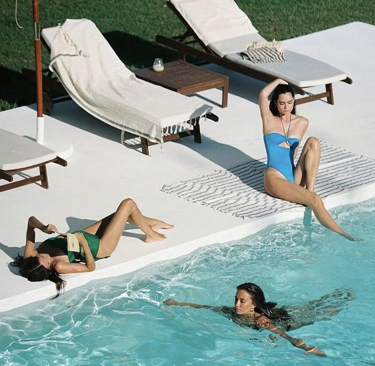 two women in swimsuits are swimming in a pool