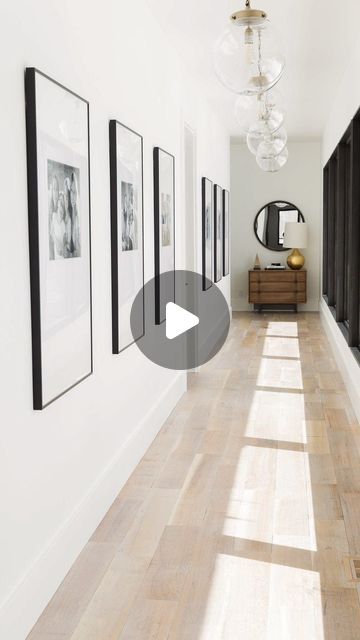 a long hallway with black and white pictures on the wall