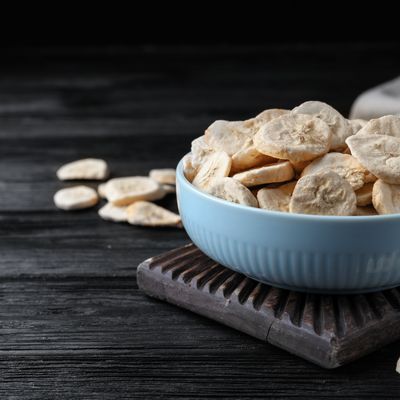 a blue bowl filled with cashews on top of a wooden table