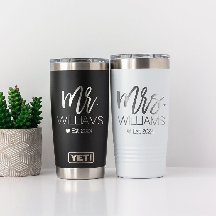 two personalized yeti tumblers next to a potted plant