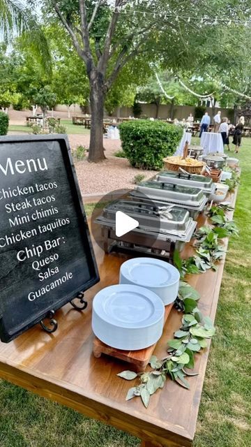 a wooden table topped with plates and bowls next to a chalkboard sign that says menu