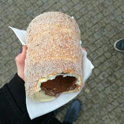 a person holding a pastry in their hand with chocolate filling on the outside and inside