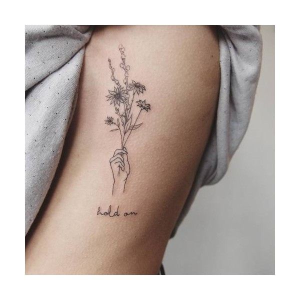 a woman's arm with flowers on it and the words hold on written in black ink