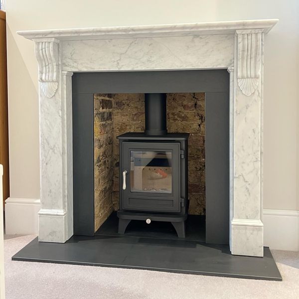 a fireplace with a stone surround and a wood burning stove in the middle of it